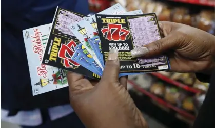  ?? Photograph: Rogelio V Solis/AP ?? A customer shows off her set of non-winning scratch-off tickets in Jackson, Mississipp­i.