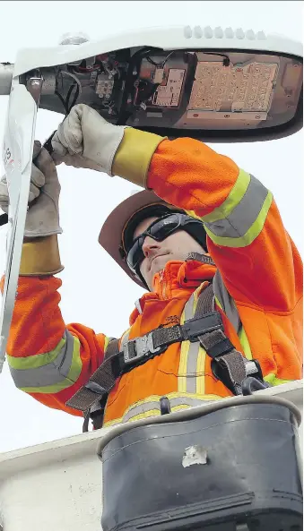  ?? TYLER BROWNBRIDG­E/WINDSOR STAR ?? Chris Carr from Enersource installs new LED lights to a light pole on St. Rose Avenue in Windsor Wednesday. The city is changing 23,500 lights across the city at a cost of $16 million.