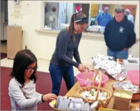  ?? BOB KEELER — DIGITAL FIRST MEDIA ?? From left, first-grader Alannah and parents Trish and John Mulqueeney, of Lower Pottsgrove, get breakfast at the Dec. 9 Breakfast with Santa to benefit Franconia Police Benevolent Associatio­n’s Shop with a Cop.