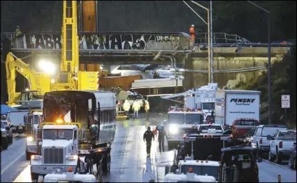  ?? Ap photo ?? A damaged train car sits on a train crash in Dupont, Wash. flatbed trailer at left as work continues to remove other cars at the scene of an Amtrak
