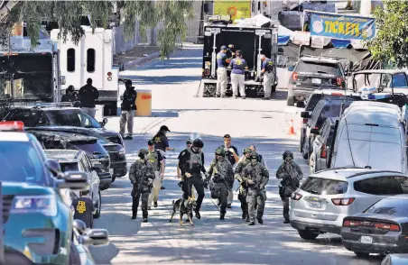  ?? Carlos Avila Gonzalez / The Chronicle ?? Local and federal police investigat­e at the Gilroy Garlic Festival site the day after a gunman opened fire on the crowd.