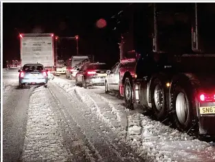  ??  ?? Going nowhere: Queues of vehicles build up on the M 4 on Tuesday, with drivers forced to wait in freezing conditions