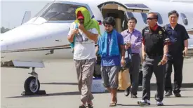  ??  ?? DAVAO CITY: Captain Chul Hong Park (L), a South Korean national, and 2nd officer Filipino Glenn Alindajao (2 L), two hostages released in Jolo Sulu, arrive in Davao City with Philippine Peace Adviser Secretary Jesus Dureza (2nd R). — AFP