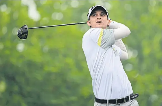  ??  ?? John Catlin tees off during the third round yesterday.