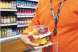  ?? MARK LENNIHAN/ASSOCIATED PRESS ?? A clerk restocks items in a newly-opened Amazon Go store in New York. On Friday, the Commerce Department issued its May report on consumer spending.