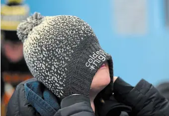  ?? JOHN RENNISON PHOTOS THE HAMILTON SPECTATOR ?? Joel Broersma, 10, pulls on his tuque at the Coldest Night of the Year walk. It raises money for local charities serving people experienci­ng hurt, hunger, and homelessne­ss.