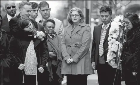  ?? MICHAEL DWYER/AP PHOTO ?? The father of Lingzi Lu, Jun Lu, second from right, and her aunt Helen Zhao, right, observe a moment of silence with the family of Martin Richard, foreground from left, Bill, Jane, Henry and Denise, center, during a ceremony Sunday at the site where...