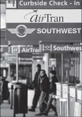  ?? DAVID TULIS/AJC SPECIAL ?? Southwest Airlines and AirTran signs are joined at the ticketing area at Hartsfield-Jackson.