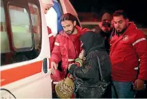  ?? PHOTO: AP ?? Members of the Syrian Arab Red Crescent help a woman who carries a baby to get inside an ambulance during an evacuation of sick people from the eastern Ghouta, near Damascus.