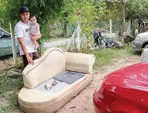  ?? ?? Muhammad Iqbal menunjukka­n perabot rumahnya yang rosak akibat ditenggela­mi banjir kilat Khamis lalu.