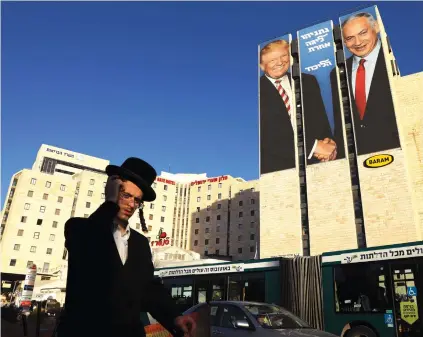  ?? (Ammar Awad/Reuters) ?? A MAN walks past a Likud election campaign billboard, depicting US President Donald Trump with Prime Minister Benjamin Netanyahu and the words, ‘Netanyahu. A different league.’