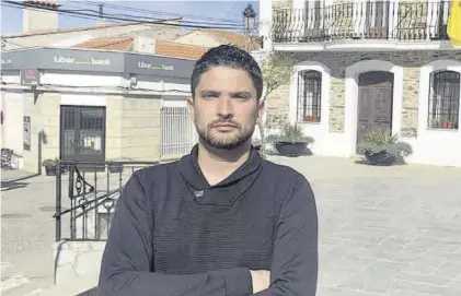  ?? EL PERIÓDICO ?? El alcalde de la localidad cacereña, Francisco Muñoz, posa delante de la oficina de Liberbank.