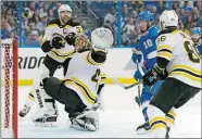  ?? CHRIS O’MEARA/AP PHOTO ?? Boston’s Tuukka Rask reaches back to make a save on Tampa Bay’s J.T. Miller’s shot Saturday during the second period of a second-round playoff series in Tampa, Fla. The Bruins’ Zdeno Chara, left, and Kevan Miller look on.