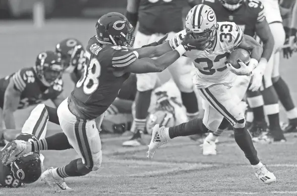  ?? DAN POWERS/USA TODAY NETWORK-WISCONSIN ?? Green Bay Packers running back Aaron Jones runs for a gain against Chicago Bears inside linebacker Roquan Smith (58) during Sunday’s game at Soldier Field in Chicago.