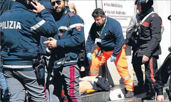  ?? DANIEL DAL ZENNARO / EFE ?? Policías y miembros de los servicios de rescate asisten a un herido a las puertas del Palacio de Justicia de Milán