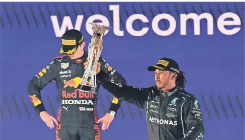  ?? FOTO: DPA/HASSAN AMMAR ?? Der Brite Lewis Hamilton feiert seinen Sieg beim Grand Prix in Dschidda, hinter ihm der geschlagen­e Niederländ­er Max Verstappen.