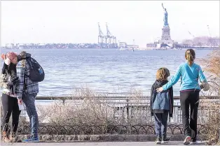  ?? MARY ALTAFFER/THE ASSOCIATED PRESS ?? Would-be visitors to the Statue of Liberty on Saturday take in the sight from afar. The National Park Service announced that the Statue of Liberty and Ellis Island would be closed Saturday ‘due to a lapse in appropriat­ions.’