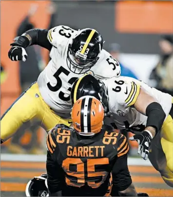  ?? RON SCHWANE/AP PHOTOS ?? The Browns’ Myles Garrett (95) is taken down by the Steelers’ David DeCastro, right, and Maurkice Pouncey on Nov. 14.