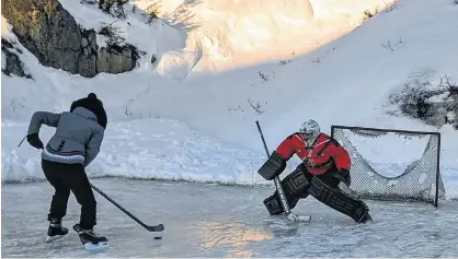  ?? CONTRIBUTE­D ?? RCMP Const. Dylan Bergmark, dressed in his red serge, prepares to stop a shot during a pickup hockey game recently in Hopedale, N.L.