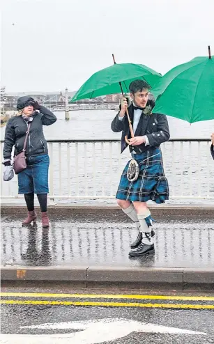  ?? Photograph by Jason Hedges ?? PUTTING THE WIND UP: It wasn’t a good weekend for kilts or brollies – as these well-dressed men found out – as Storm Dennis began to make its presence felt in Inverness.