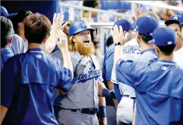  ?? ASSOCIATED PRESS ?? LOS ANGELES DODGERS’ JUSTIN TURNER (CENTER) CELEBRATES against the Miami Marlins on Sunday in Miami. with teammates after hitting a home run during the first inning