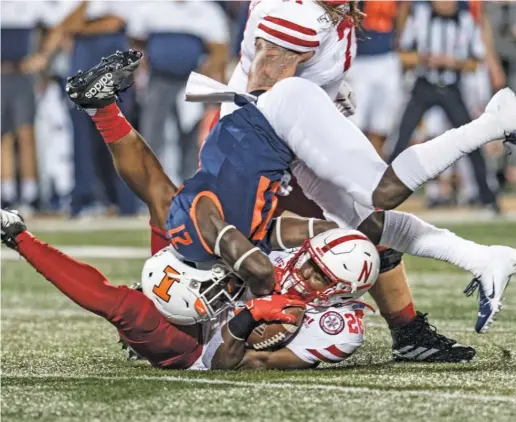  ?? HOLLY HART/AP ?? Nebraska’s Dedrick Mills, who had two touchdown runs, is brought down by Illinois’ Jartavius Martin in the first half Saturday night.