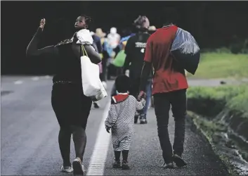  ?? AP PHOTO/MARCO UGARTE ?? Haitian migrants walk along the highway in Huixtla, Chiapas state, Mexico, early on Thursday in their journey north toward the U.S.