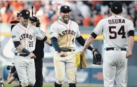  ?? ERIC CHRISTIAN SMITH THE ASSOCIATED PRESS ?? Astros’ Josh Reddick, left, George Springer and Roberto Osuna celebrate after their 7-2 win over the Cleveland Indians in Game 1 of their ALDS series Friday in Houston.