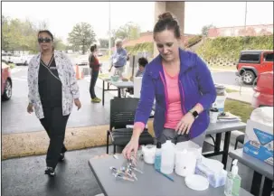  ?? The Sentinel-Record/Mara Kuhn ?? FLU SHOTS: Kari Weston, an RN student at College of the Ouachitas, prepares shots during a flu shot clinic at the Garland County Library on Friday.