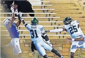  ??  ?? Tulsa wide receiver JuanCarlos Santana (5) catches a pass for a touchdown in front of Tulane safety Larry Brooks (31) and defensive back Kevaris Hall (25) at the end of regulation Thursday. Tulsa won 30-24 in double overtime. [AP PHOTO/SUE OGROCKI]