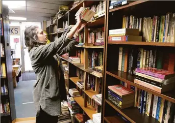  ?? H John Voorhees III / Hearst Connecticu­t Media ?? Paige Newman, of Bethel, stacks books on the shelves of Relay Bookhouse for the store’s liquidatio­n sale on Wednesday. Windy Cats Estate Sales is handling the sale. Owner Joel Orton died in August.