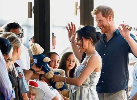  ?? — Reuters ?? Furry welcome: Meghan and Harry receiving teddy bears from members of the public at Kingfisher Bay on Fraser Island.