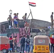  ?? (AFP) ?? Iraqis at a roadblock on Al-Ahrar bridge, in Baghdad on Wednesday