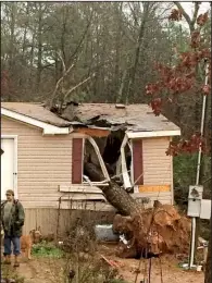  ?? AP/Pope County sheriff’s office ?? High winds sent this tree crashing into the bedroom of this house near Atkins on Wednesday, killing a woman and injuring her toddler sister. A neighbor said a firefighte­r friend carried the child out of the home after rescuers used jacks and air bags to get to her and her sister.