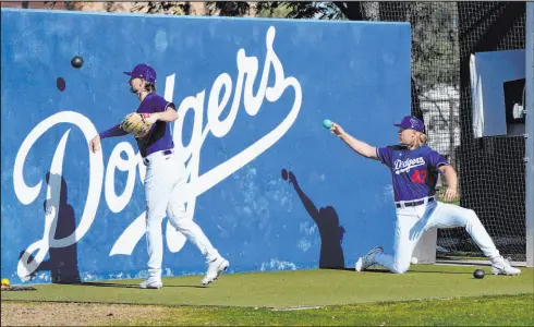  ?? Ross D. Franklin
The Associated Press ?? Pitchers Shelby Miller, left, and Noah Syndergaar­d warm up as the Dodgers opened training camp last week in Phoenix.