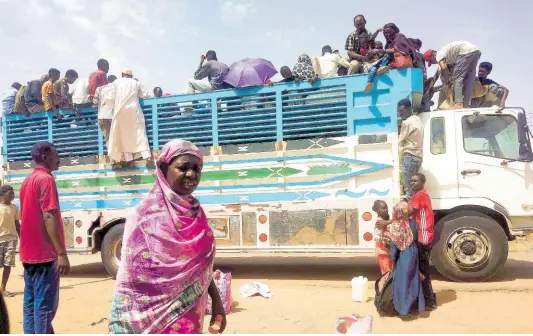  ?? AP ?? People board a truck as they leave Khartoum, Sudan, on June 19, 2023.