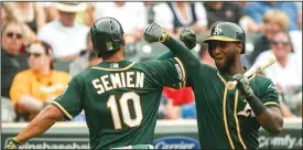  ?? NICOLE NERI/TRIBUNE NEWS SERVICE ?? Oakland Athletics shortstop Marcus Semien (10) is congratula­ted after hitting a home run in the first inning at Target Field on Friday in Minneapoli­s, Minn.