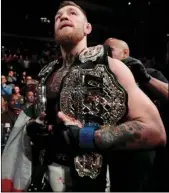  ?? AP PHOTO/JULIO CORTEZ ?? In this Nov. 13, 2016, file photo, Conor McGregor leaves the octagon with his title belts after knocking out Eddie Alvarez during a lightweigh­t mixed martial arts bout at UFC 205 at Madison Square Garden in New York. McGregor’s run as UFC lightweigh­t...