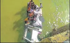  ?? AFP ?? People rescuing passengers after a mini bus ferrying a wedding party fell into a river in Rajasthan while crossing a bridge.