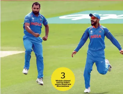  ?? AFP ?? Mohammed Shami (left) celebrates the wicket of New Zealand’s Neil Broom with India’s captain Virat Kohli. —