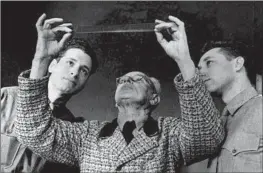  ?? Kino Lorber ?? HITLER’S photograph­er, Heinrich Hoffmann, center, inspects film as Stuart Schulberg, right, looks on in an image from “Filmmakers for the Prosecutio­n.”