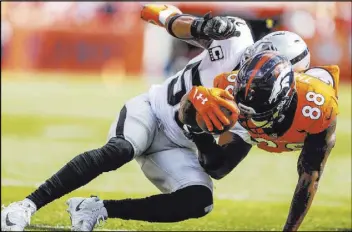  ?? Jack Dempsey The Associated Press ?? Raiders linebacker Derrick Johnson, left, crunches Broncos wide receiver Demaryius Thomas in the second half on Sept. 16 in Denver.