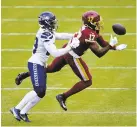  ?? SUSANWALSH/AP ?? Washington receiver Terry McLaurin juggles the ball while being covered by Seattle’s D.J. Reed on Sunday.