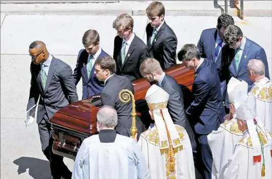 ?? Matt Freed/Post-Gazette ?? Pallbearer­s carry the casket of Steelers president Dan Rooney after his funeral Mass at St. Paul Cathedral in Oakland on Tuesday. At the head of the casket are former Steeler Ike Taylor, left, and grandson Danny Rooney, right, leading a procession that...