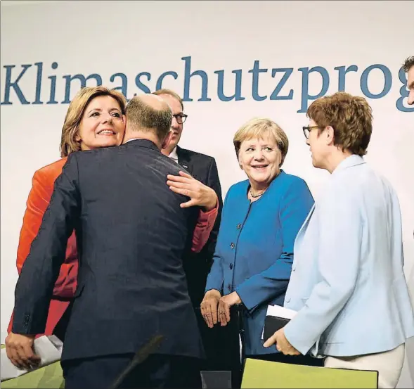  ??  ?? La canciller Merkel y su ministro de Finanzas, Olaf Scholz (de espaldas), con representa­ntes de los partidos en el Gobierno