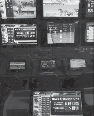  ?? JON LENDER/HARTFORD COURANT ?? Sportech, the operator of off-track betting (OTB) in Connecticu­t, is one of the contenders — along with tribes that operate casinos, gaming giant MGM, the Connecticu­t Lottery Corp., and, potentiall­y, daily sports fantasy companies — to win state approval to run all or part of a new sports wagering system that the General Assembly expects to approve this year. Shown here are OTB screens — displaying gambling venues across the country — at Shea’s Pizzeria and Sports Bar in Manchester.