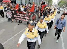  ??  ?? Uniformado­s escoltaron a los embozados del Ángel hacia el Zócalo.