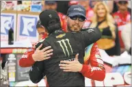  ?? Donald Page / Getty Images ?? Kurt Busch, front, congratula­tes Kyle Busch in Victory Lane after Kyle won at Bristol Motor Speedway on Sunday in Bristol, Tenn.