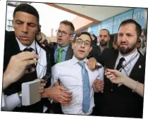  ??  ?? Disruption: Simon Brodkin is taken out of the Tory conference after interrupti­ng the Prime Minister