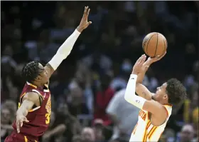  ?? NICK CAMMETT - THE ASSOCIATED PRESS ?? Atlanta Hawks’ Trae Young, right, shoots against Cleveland Cavaliers’ Isaac Okoro during the first half of an NBA play-in basketball game Friday, April 15, 2022, in Cleveland.